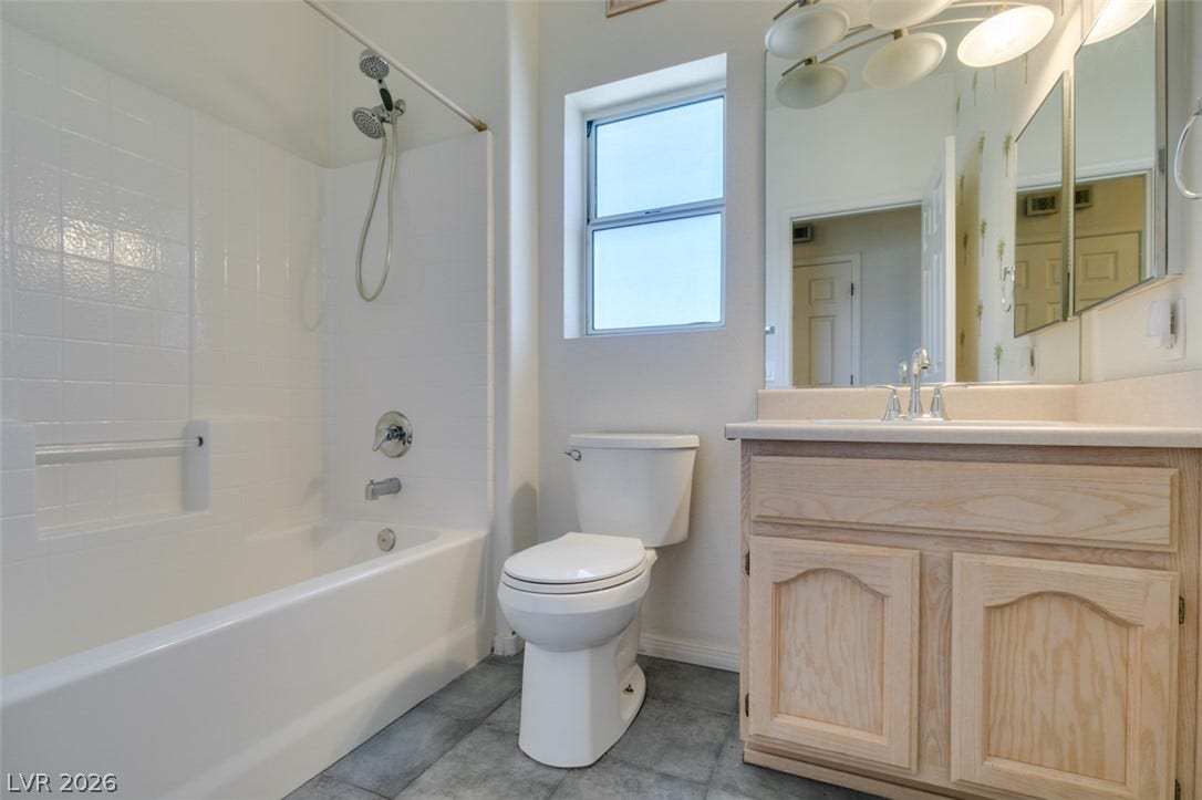 Tiled flooring and a classic wooden vanity define this functional bathroom space.