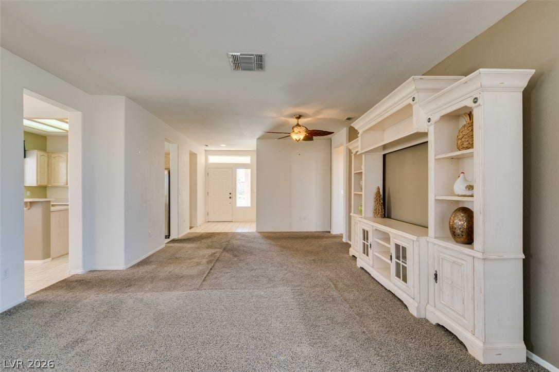 An open floor plan connects the carpeted living room to the adjacent kitchen area.