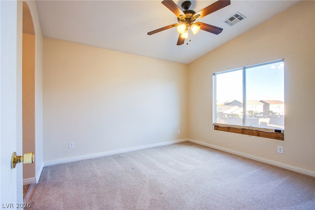 6717 Lookout Lodge Lane, #1, North Las Vegas, NV 89084 A spacious bedroom features comfortable neutral carpeting and a wide window with neighborhood views.