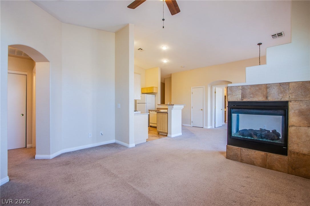 6717 Lookout Lodge Lane, #1, North Las Vegas, NV 89084 An open floor plan connects the carpeted living space to the adjacent kitchen.