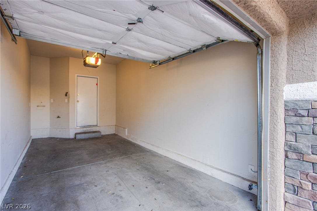 6717 Lookout Lodge Lane, #1, North Las Vegas, NV 89084 An attached garage features concrete flooring and a solid service door leading inside.