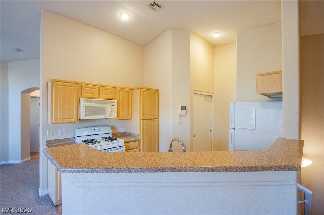 6717 Lookout Lodge Lane, #1, North Las Vegas, NV 89084 High ceilings and a wraparound breakfast bar define this open kitchen space.