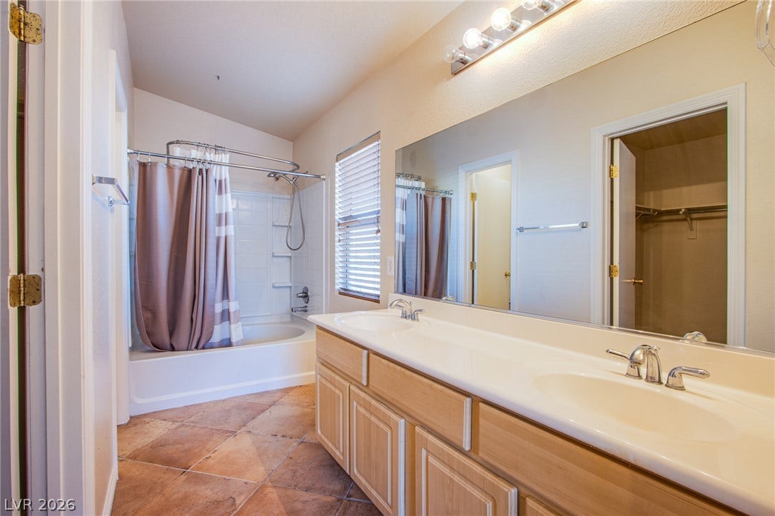 6717 Lookout Lodge Lane, #1, North Las Vegas, NV 89084 A spacious vanity with dual sinks highlights this well-appointed bathroom with tiled flooring.