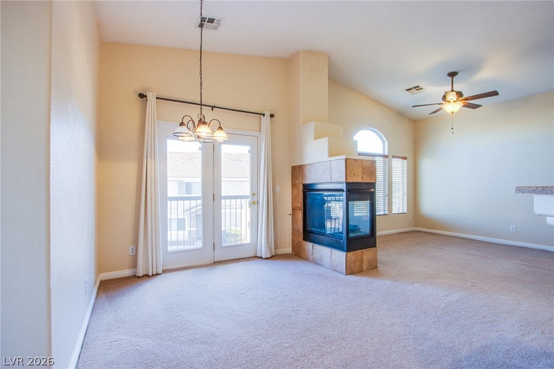 6717 Lookout Lodge Lane, #1, North Las Vegas, NV 89084 An open floorplan centers around a three-sided tile fireplace under towering vaulted ceilings.