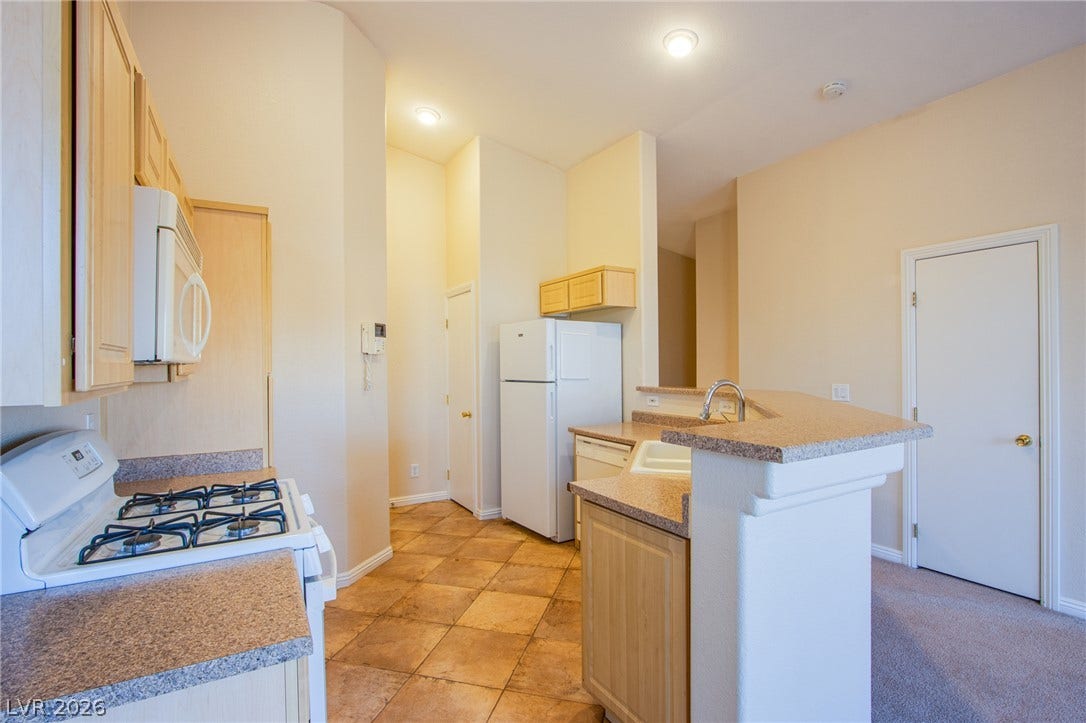 6717 Lookout Lodge Lane, #1, North Las Vegas, NV 89084 Warm tile flooring and classic wood cabinetry define this functional cooking space.