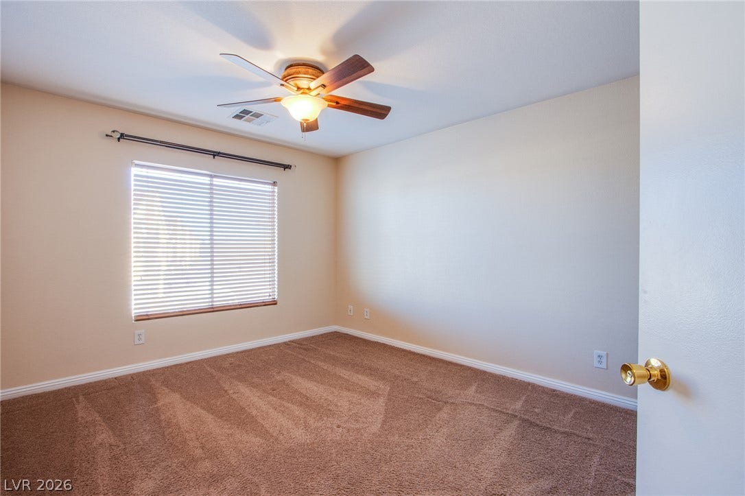 6717 Lookout Lodge Lane, #1, North Las Vegas, NV 89084 Plush carpeted flooring and a wide window with integrated blinds highlight this versatile bedroom.