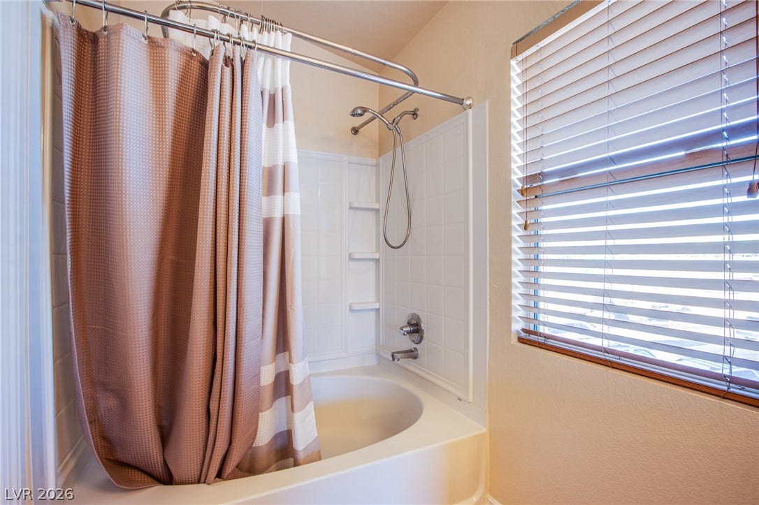 6717 Lookout Lodge Lane, #1, North Las Vegas, NV 89084 Natural light pours through a large window adjacent to this shower and tub combination.
