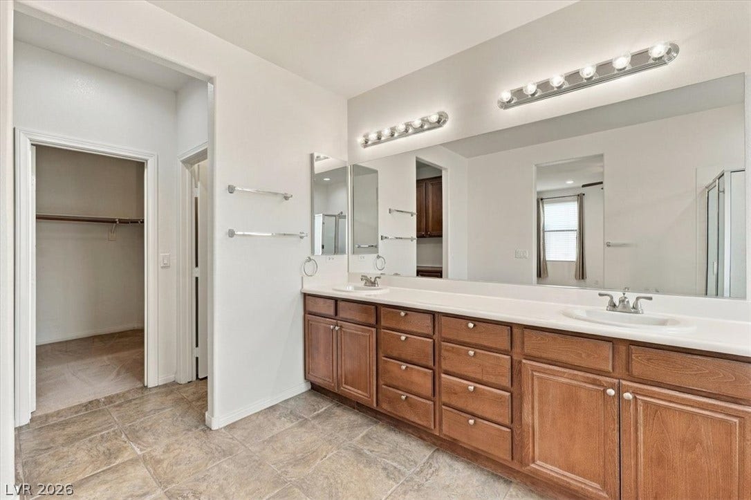A spacious vanity with dual sinks anchors this well-appointed bathroom suite.