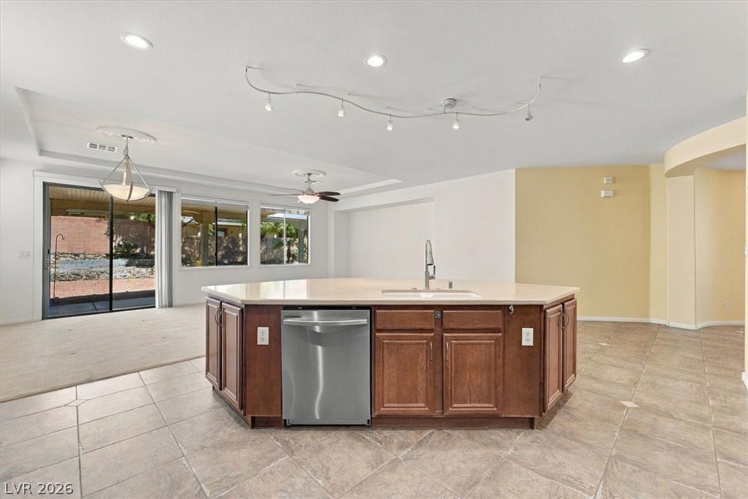 A spacious kitchen flows seamlessly into the bright, open living spaces beyond.