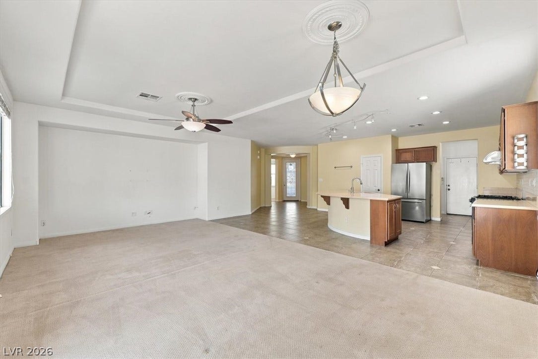 An open layout connects the carpeted living space directly to the kitchen area.