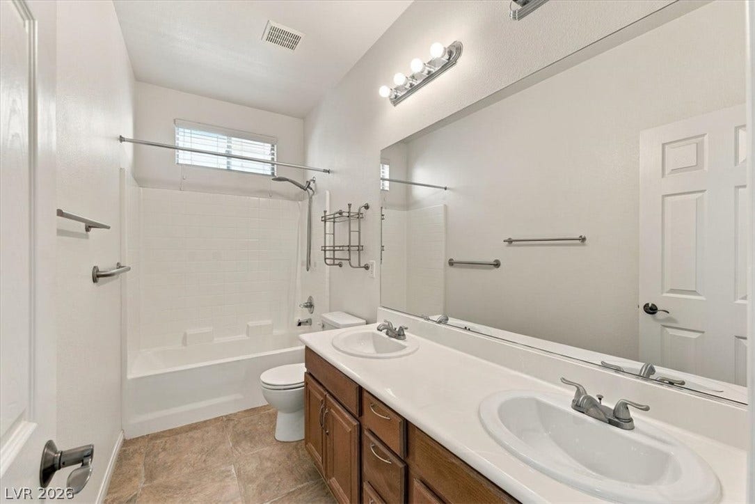 Double vanity sinks and tile flooring create a highly functional main bath layout.
