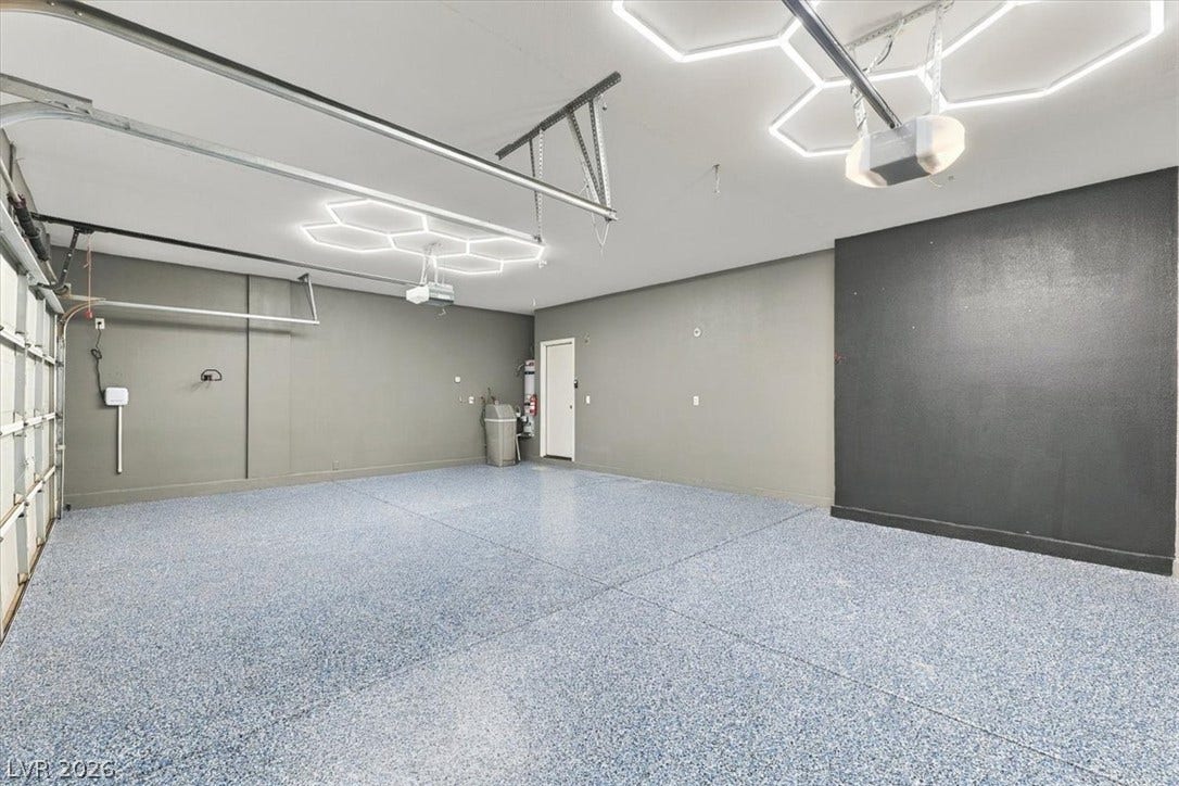 Finished epoxy flooring and custom overhead lighting define this spacious multi-car garage.