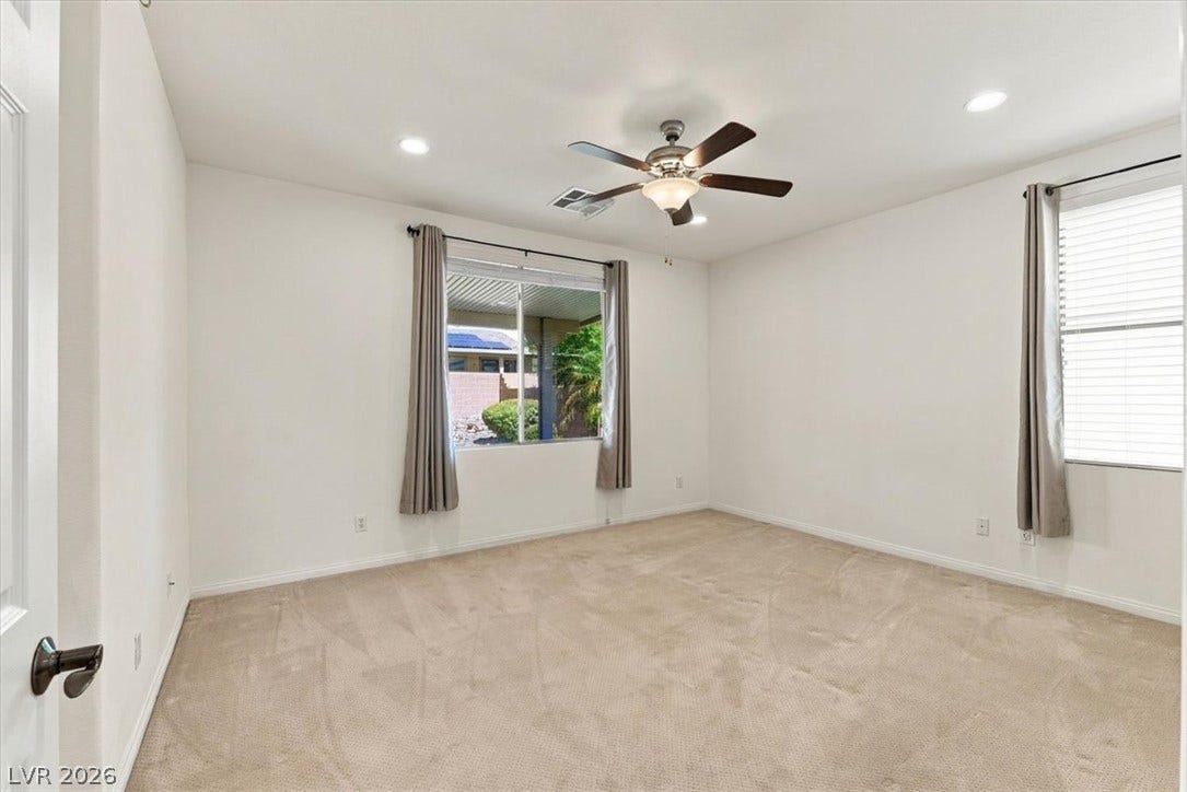 Plush carpeting and recessed lighting create a comfortable atmosphere in this versatile bedroom.