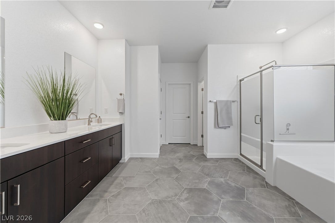 544 Front Range Lane, North Las Vegas, NV 89084 Hexagonal floor tiles and a spacious double vanity elevate this contemporary primary bathroom.