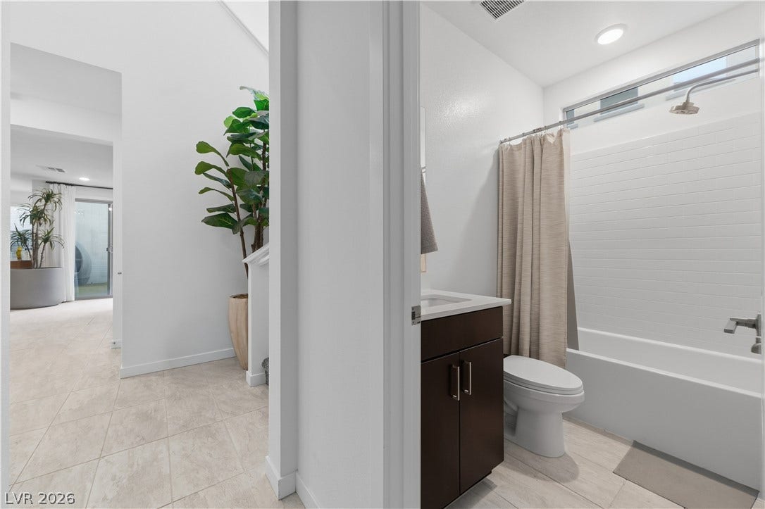 544 Front Range Lane, North Las Vegas, NV 89084 High ceilings and clean tiled floors define this modern bathroom and adjacent hallway.