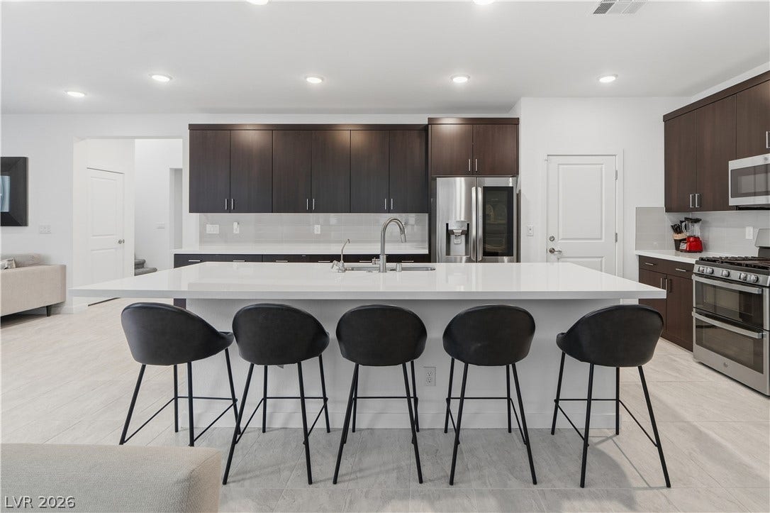 544 Front Range Lane, North Las Vegas, NV 89084 Dark cabinetry beautifully contrasts with light countertops and an expansive central island.