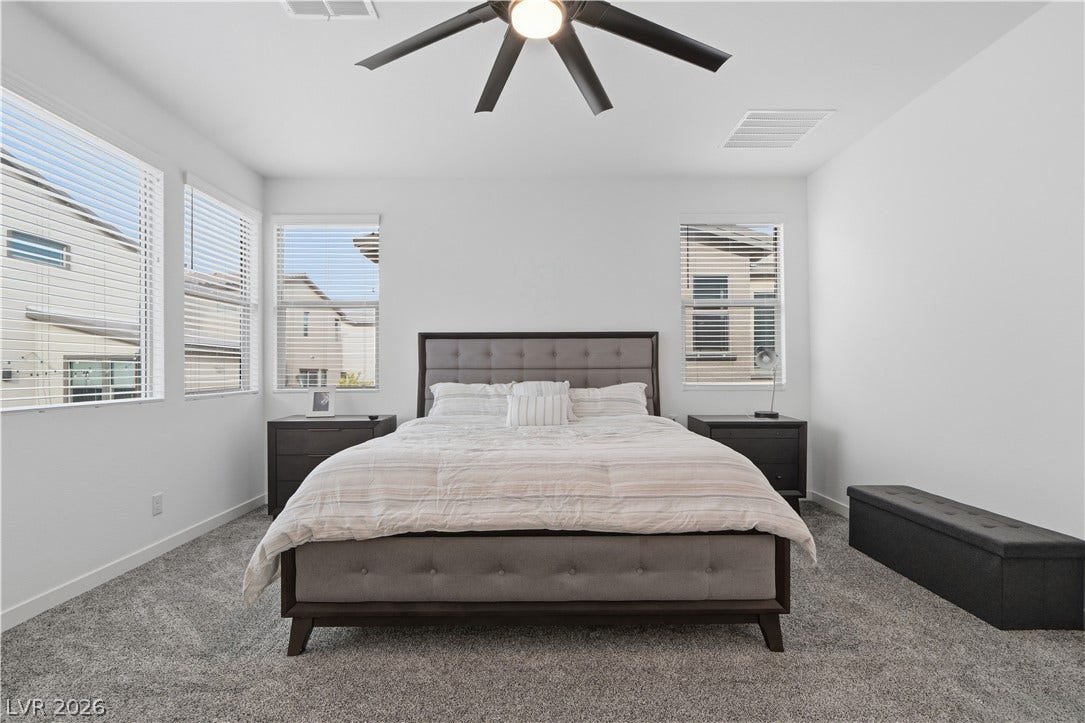 544 Front Range Lane, North Las Vegas, NV 89084 Plentiful natural light fills a tranquil sleeping space featuring plush carpeting.