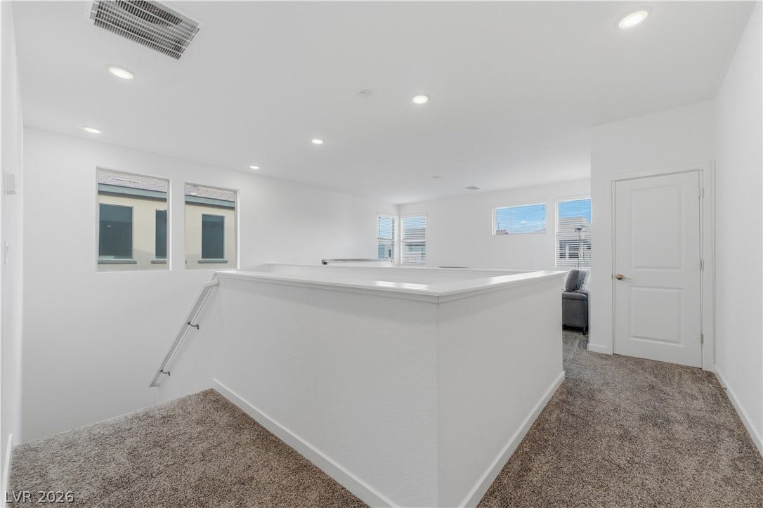 544 Front Range Lane, North Las Vegas, NV 89084 Recessed lighting illuminates this upper landing with plush carpeting and natural light.