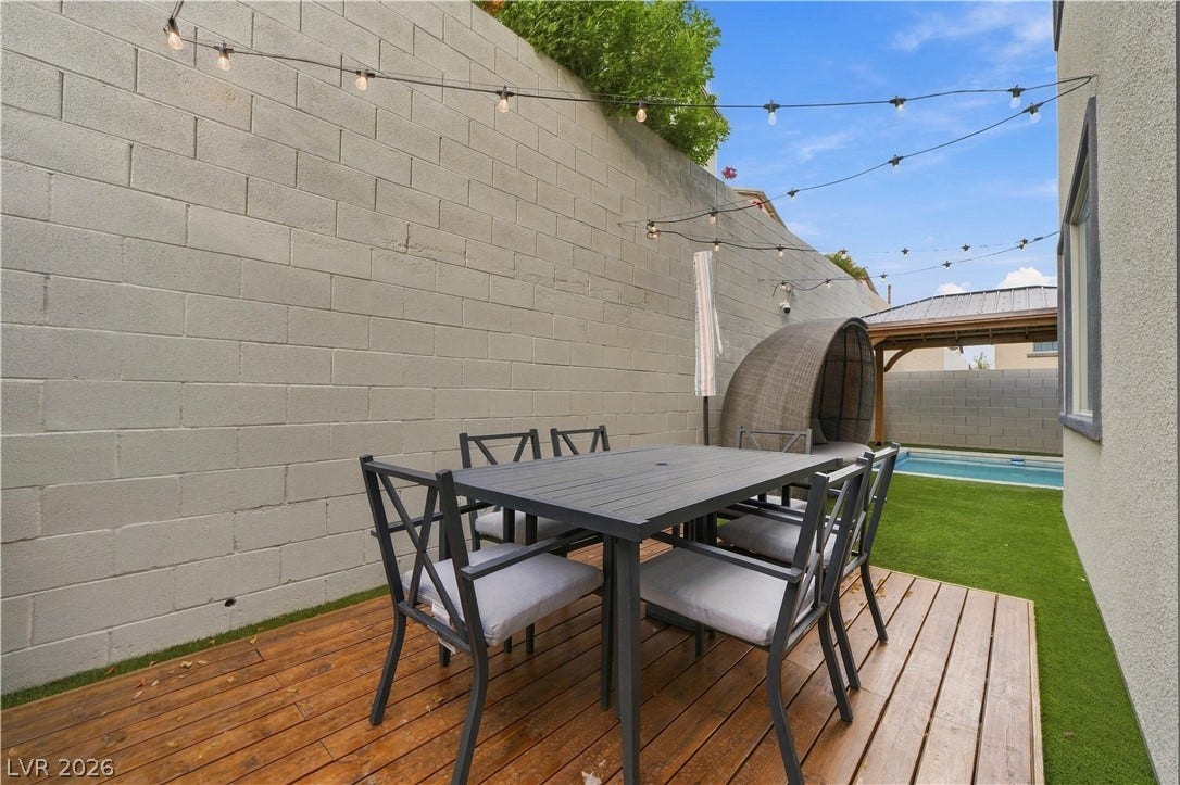 544 Front Range Lane, North Las Vegas, NV 89084 A wooden deck sits beside a towering stone wall overlooking the backyard pool.