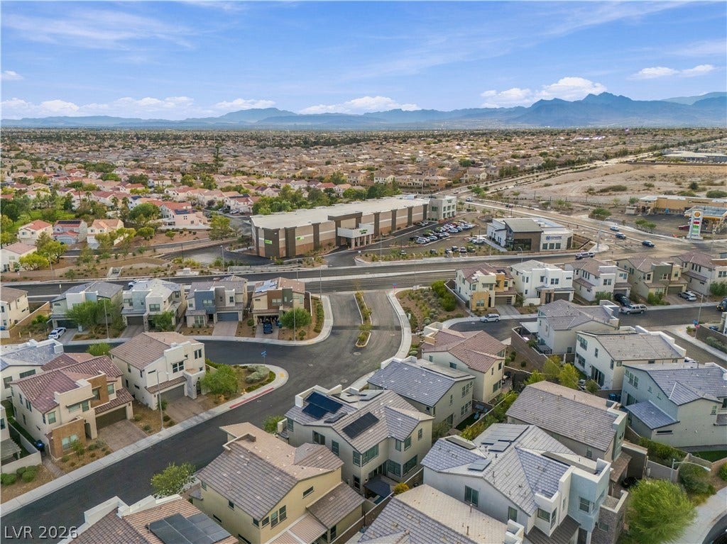 544 Front Range Lane, North Las Vegas, NV 89084 An aerial view showcases a modern residential neighborhood set against a backdrop of distant mountains.