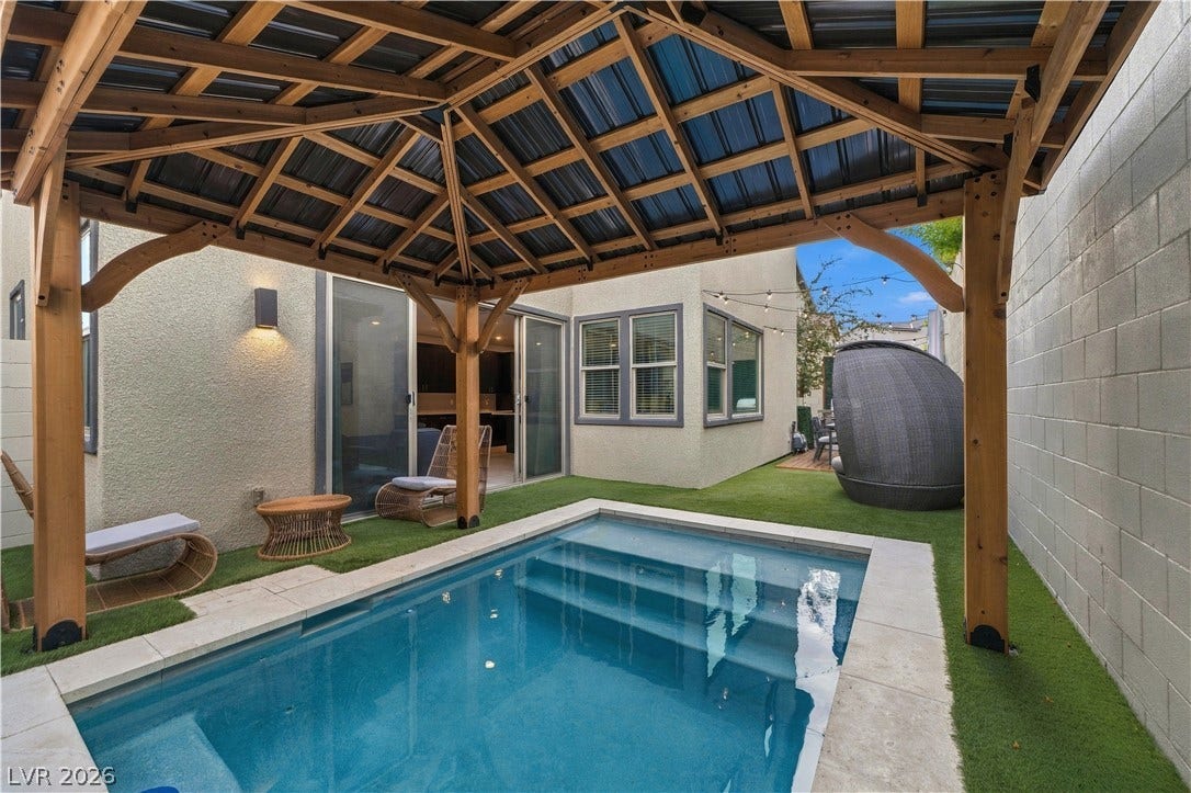 544 Front Range Lane, North Las Vegas, NV 89084 An inviting backyard oasis features a glistening plunge pool nestled under a wooden pavilion structure.