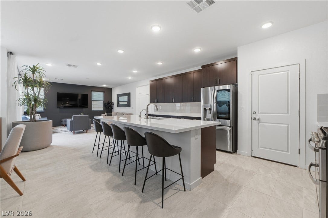 544 Front Range Lane, North Las Vegas, NV 89084 An open floorplan seamlessly connects the modern kitchen and living spaces over tile flooring.