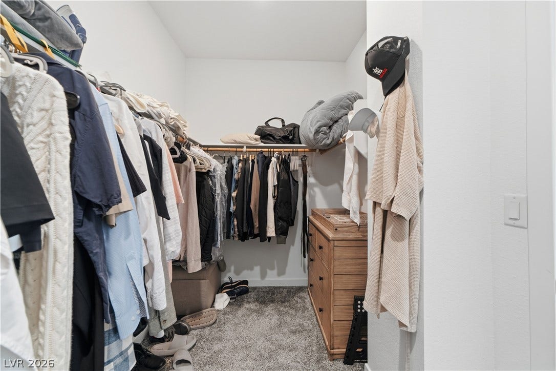 544 Front Range Lane, North Las Vegas, NV 89084 Plush carpeting lines this functional walk-in closet featuring extensive built-in hanging rods.