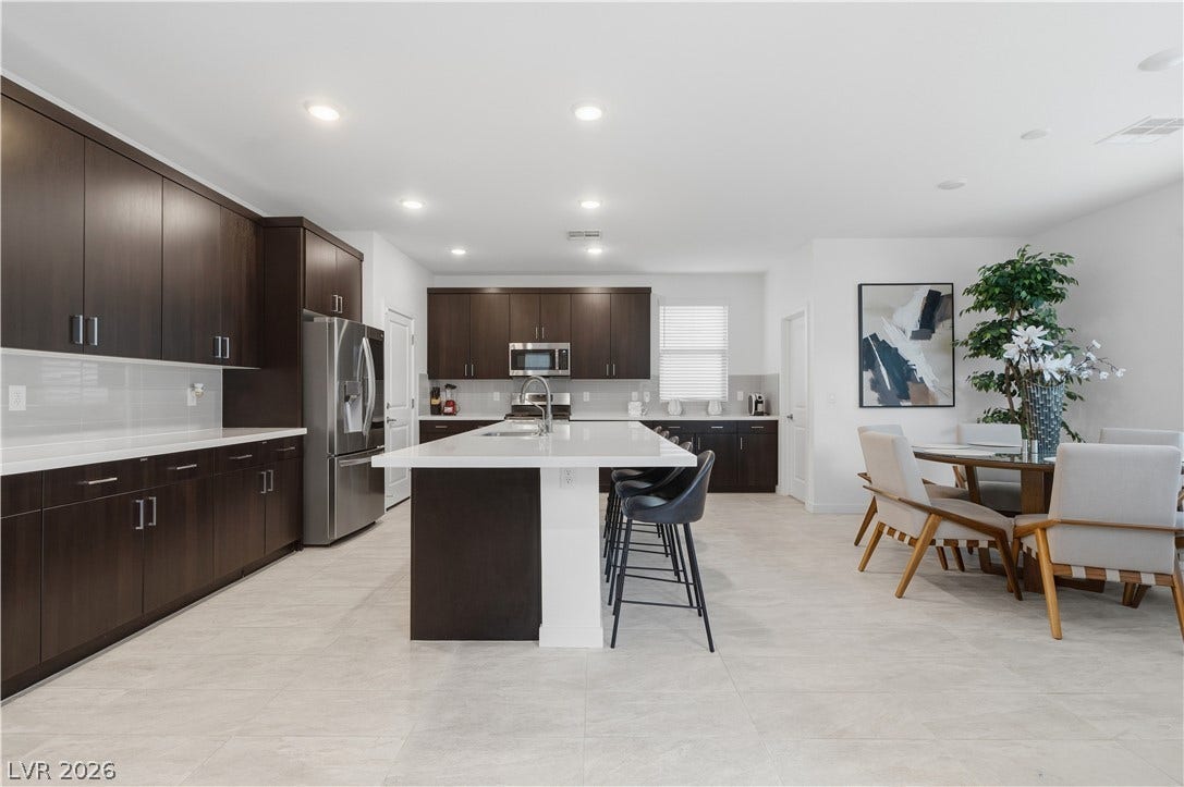 544 Front Range Lane, North Las Vegas, NV 89084 An open kitchen highlights sleek modern cabinetry alongside an expansive central prep island.
