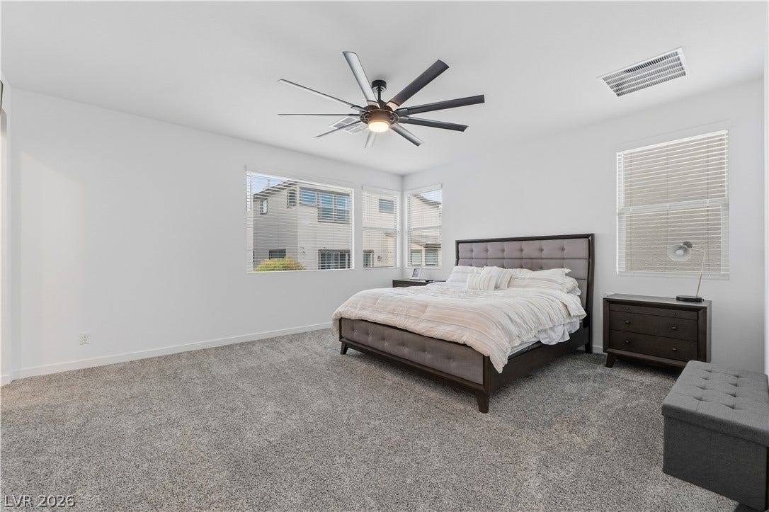 544 Front Range Lane, North Las Vegas, NV 89084 Plentiful natural light streams through multiple windows across plush carpeted flooring.