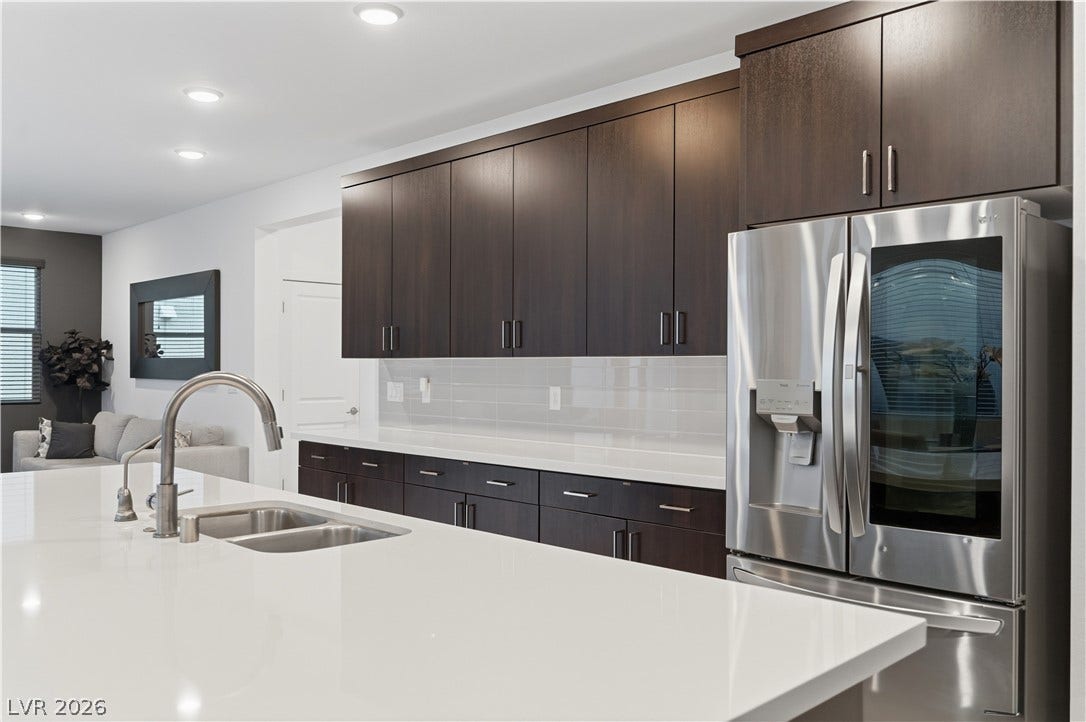 544 Front Range Lane, North Las Vegas, NV 89084 Rich dark cabinetry contrasts beautifully with clean white countertops and modern stainless steel appliances.