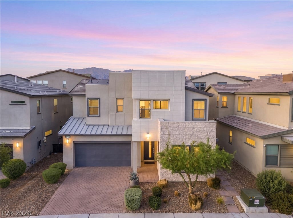 544 Front Range Lane, North Las Vegas, NV 89084 Modern multi-textured exterior showcases clean lines, stone accents, and a paver driveway under twilight skies.