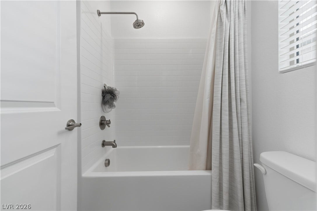 544 Front Range Lane, North Las Vegas, NV 89084 Clean horizontal tile surrounds the integrated bathtub and shower combination.