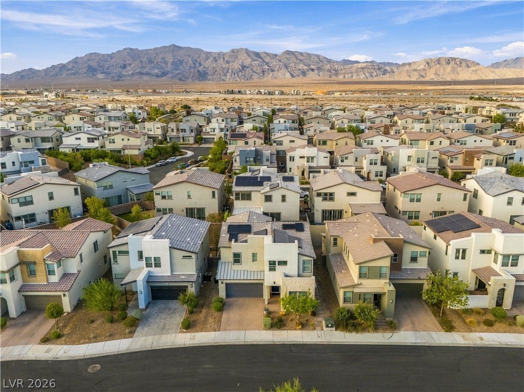 544 Front Range Lane, North Las Vegas, NV 89084 An aerial perspective reveals a modern residential neighborhood set against a dramatic desert mountain backdrop.