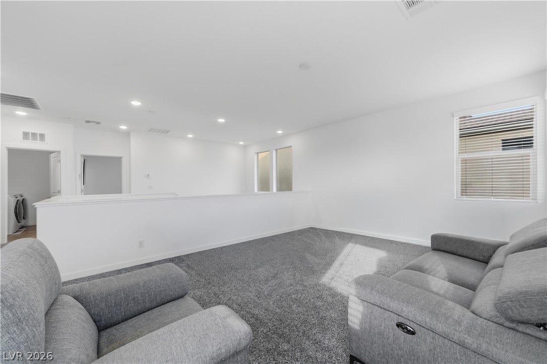 544 Front Range Lane, North Las Vegas, NV 89084 An open upstairs loft features plush carpeting, recessed lighting, and a half-wall overlooking the lower level.