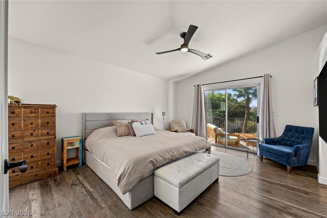 1421 Dragon Rock Drive, Henderson, NV 89052 Sliding glass doors open to a private balcony from this spacious bedroom with hardwood flooring.