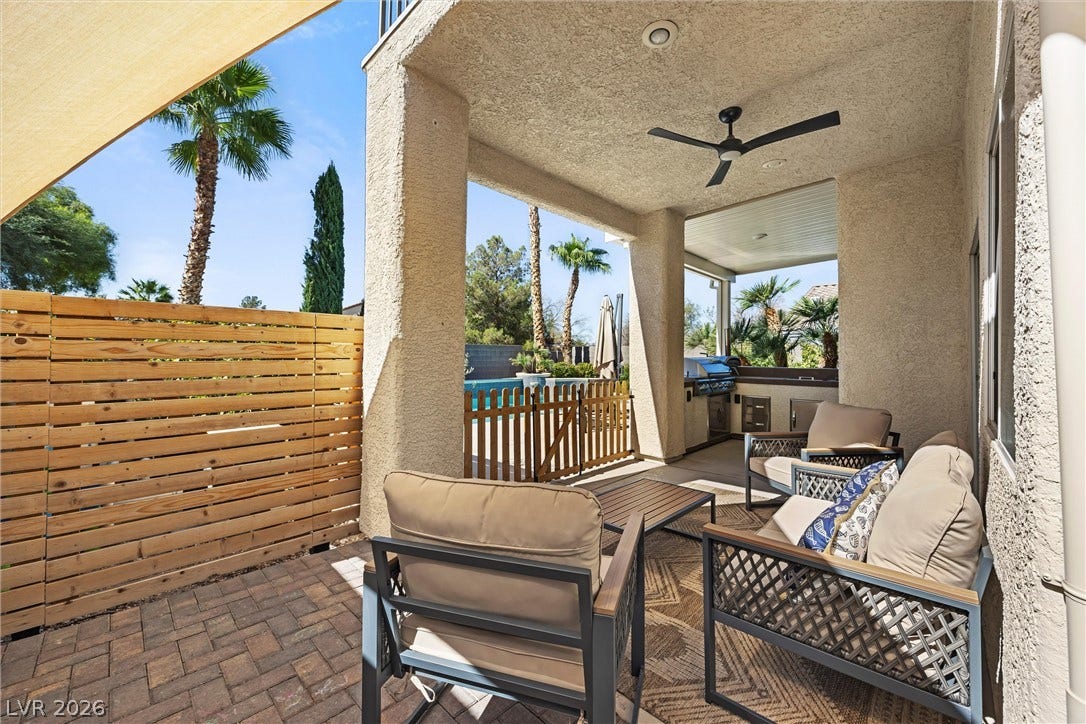 1421 Dragon Rock Drive, Henderson, NV 89052 A shaded patio paved with brick features robust stucco pillars and a wood privacy fence.