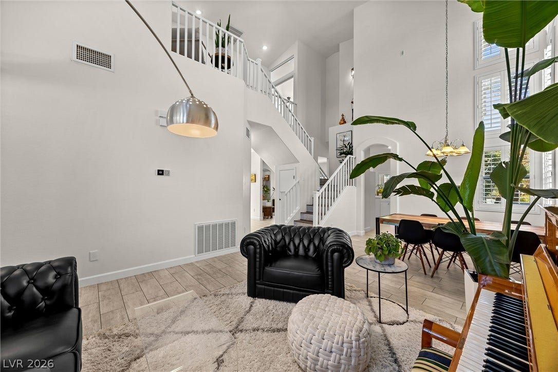 1421 Dragon Rock Drive, Henderson, NV 89052 Double-height ceilings and a sweeping staircase anchor this open-concept main living area.