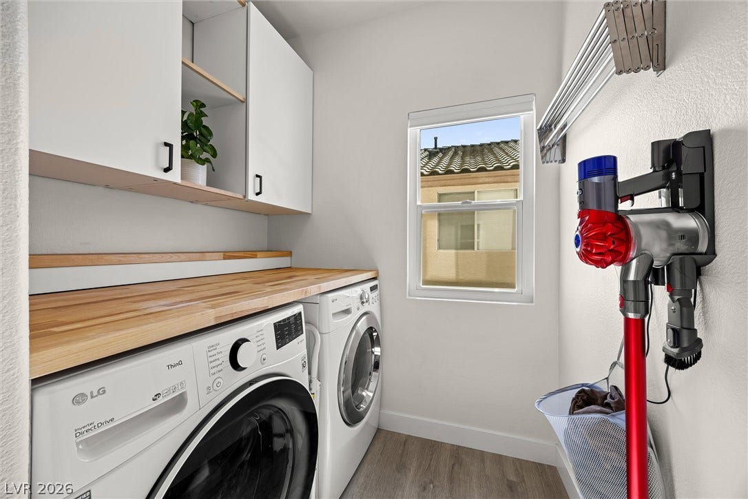 1421 Dragon Rock Drive, Henderson, NV 89052 A well-organized laundry workspace features butcher block folding counters and custom overhead cabinetry.