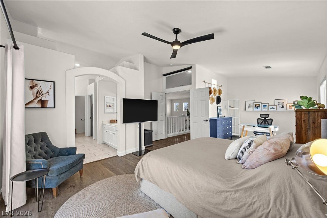 1421 Dragon Rock Drive, Henderson, NV 89052 An arched doorway and rich wood flooring define this comfortable main-level bedroom suite.