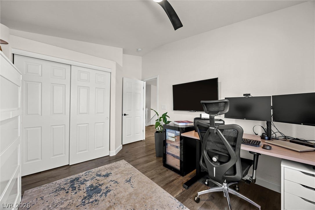 1421 Dragon Rock Drive, Henderson, NV 89052 Gleaming hardwood floors and a vaulted ceiling elevate this versatile bedroom space.