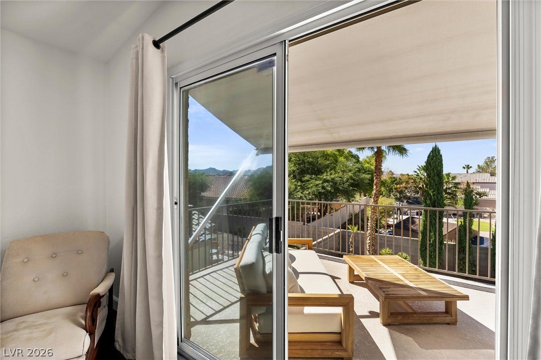 1421 Dragon Rock Drive, Henderson, NV 89052 Sliding glass doors open directly to a private balcony overlooking the neighborhood trees.