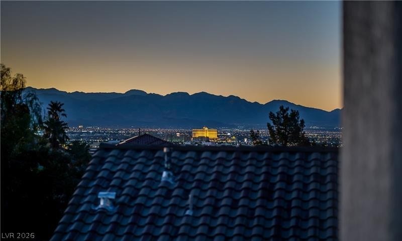 1421 Dragon Rock Drive, Henderson, NV 89052 Distant city lights and rugged mountain silhouettes create a dramatic twilight backdrop.