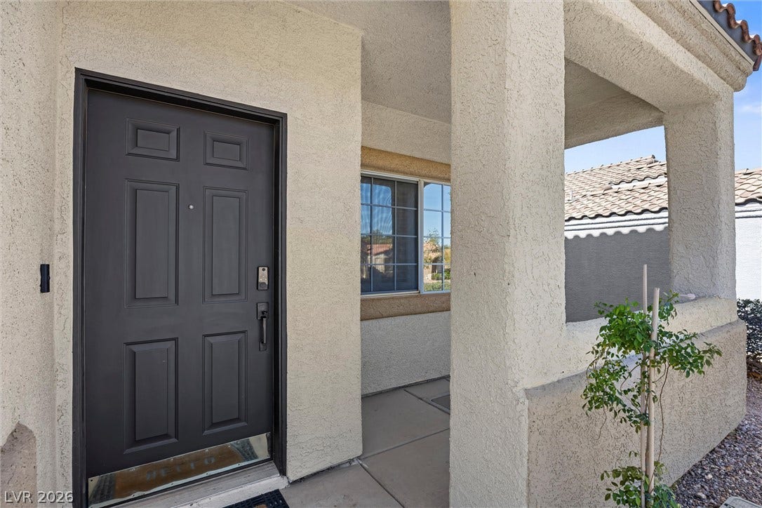 1421 Dragon Rock Drive, Henderson, NV 89052 A welcoming front entry features textured stucco pillars and a handsome paneled door.