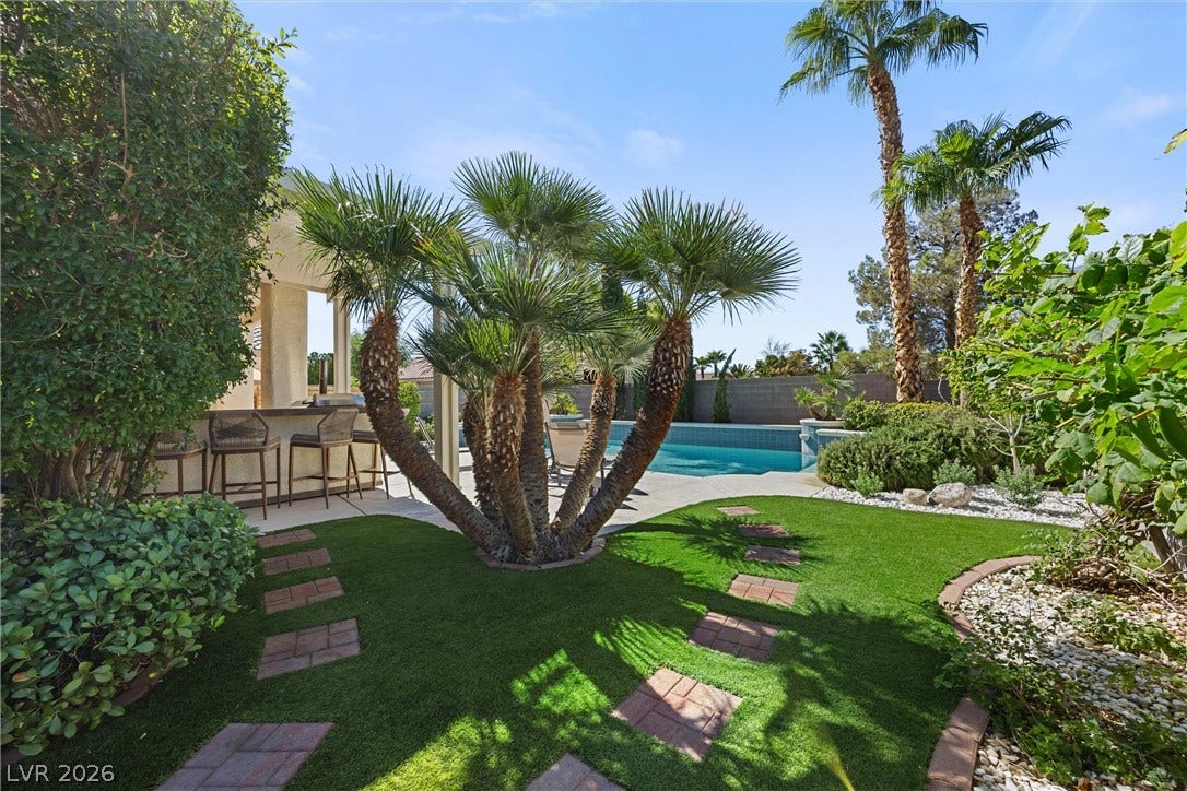 1421 Dragon Rock Drive, Henderson, NV 89052 Lush tropical plantings and stepping stones frame a sparkling pool and outdoor bar area.