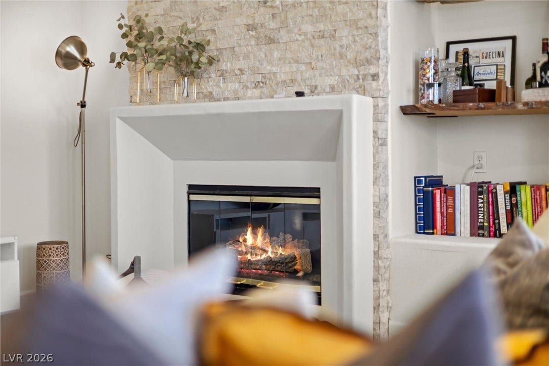 1421 Dragon Rock Drive, Henderson, NV 89052 An elegant stone fireplace serves as a warm focal point next to built-in shelving.