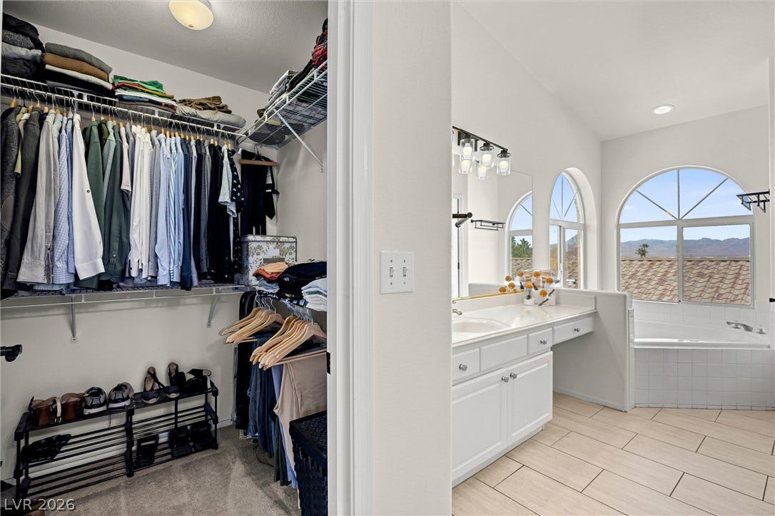 1421 Dragon Rock Drive, Henderson, NV 89052 An organized walk-in closet sits adjacent to a bright bathroom featuring tiled floors.