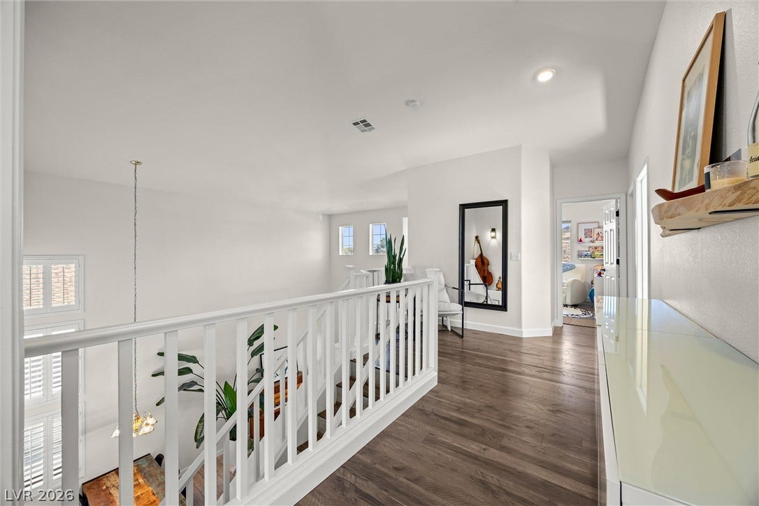 1421 Dragon Rock Drive, Henderson, NV 89052 Gleaming hardwood floors and a white railing define this open upper-level landing.