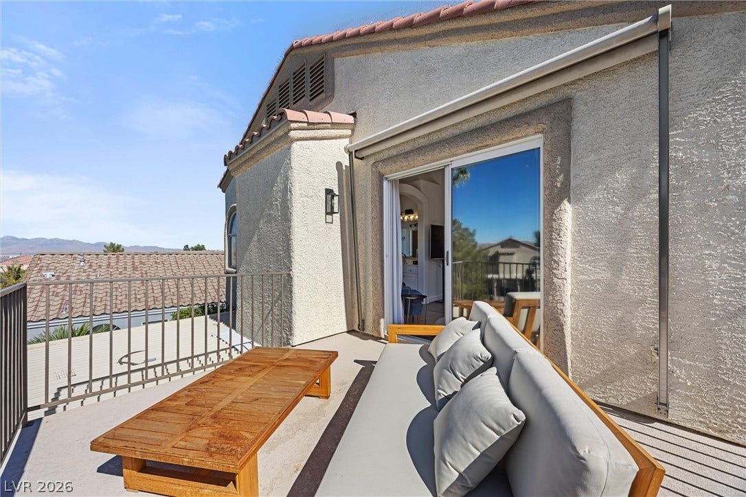 1421 Dragon Rock Drive, Henderson, NV 89052 A private upper-level balcony presents sweeping neighborhood views and stucco exteriors.