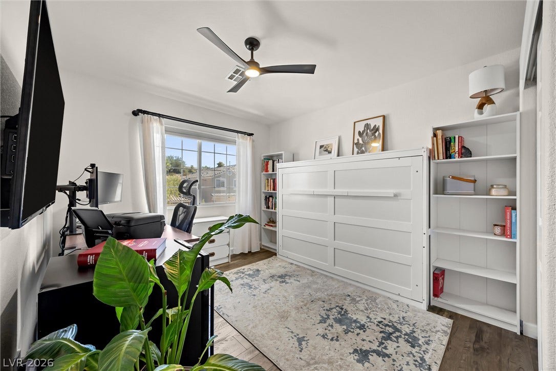 1421 Dragon Rock Drive, Henderson, NV 89052 Rich wood-inspired floors and a large multi-pane window enhance this versatile home workspace.