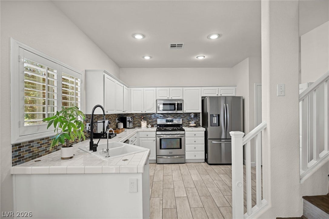 1421 Dragon Rock Drive, Henderson, NV 89052 Gleaming tile floors and custom tile countertops define this bright, open culinary space.